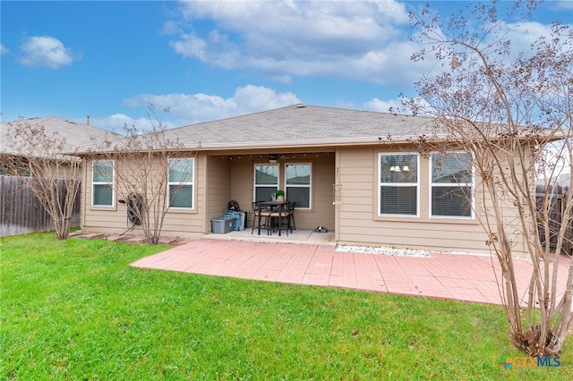 back of property with a lawn and a patio