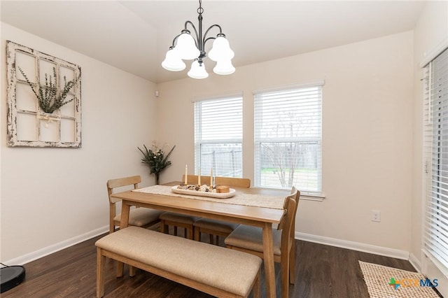 dining area featuring dark wood-type flooring and a chandelier