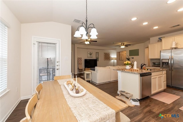 dining room featuring a wealth of natural light, sink, ceiling fan with notable chandelier, and dark hardwood / wood-style floors