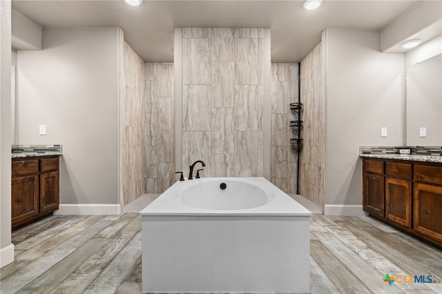125 Savage Cir, Copperas Cove, TX 76522 - full bath featuring vanity, a garden tub, wood finished floors, baseboards, and recessed lighting