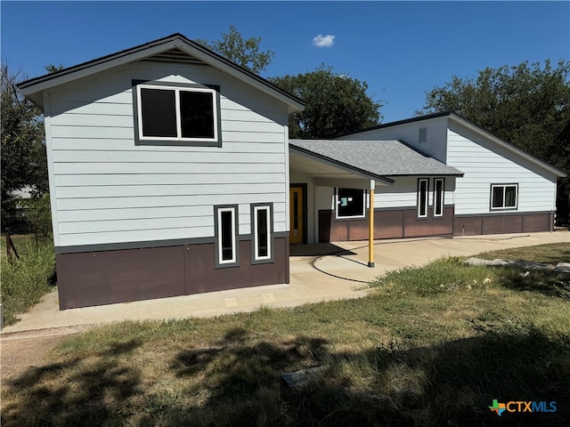 back of property featuring a lawn and a patio