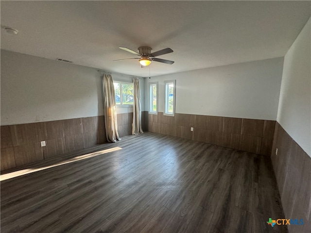 empty room featuring dark wood-type flooring and ceiling fan