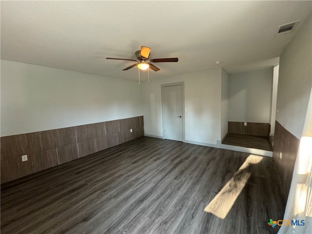 spare room with ceiling fan, a textured ceiling, and dark hardwood / wood-style flooring