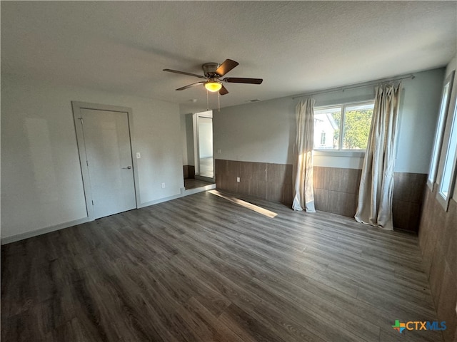 unfurnished bedroom with ceiling fan, dark hardwood / wood-style floors, and a textured ceiling