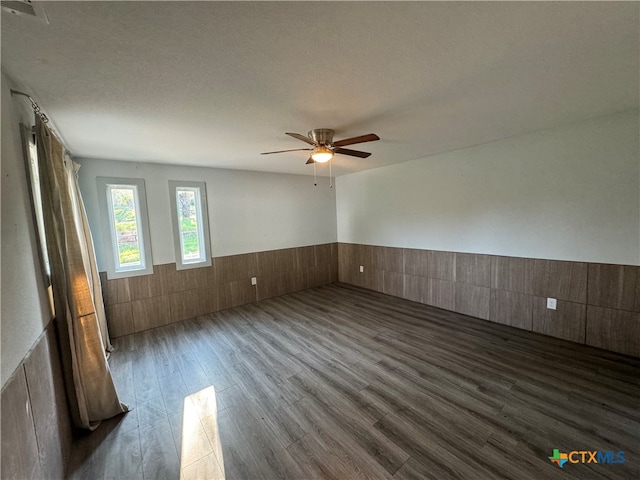 spare room featuring ceiling fan, dark hardwood / wood-style floors, and a textured ceiling