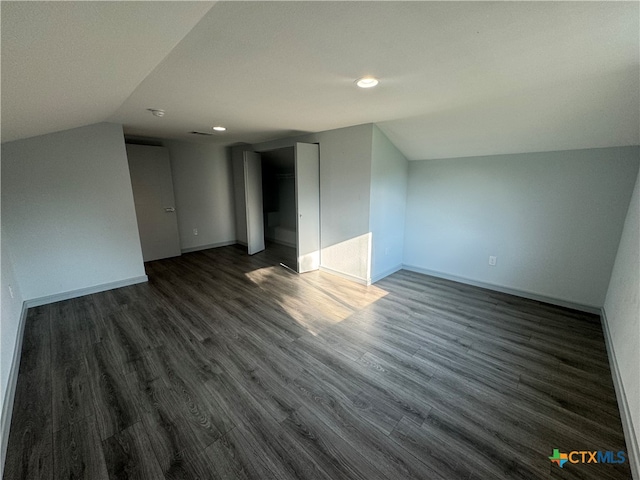 additional living space featuring lofted ceiling and dark hardwood / wood-style floors