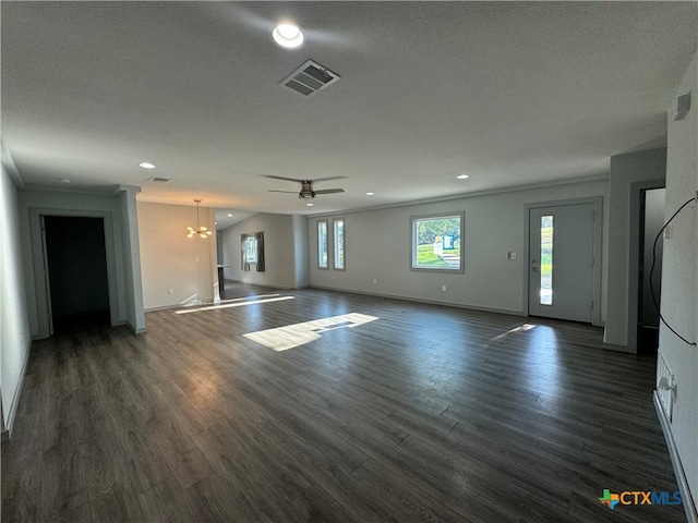 unfurnished living room featuring ceiling fan with notable chandelier, dark wood-type flooring, a textured ceiling, and crown molding