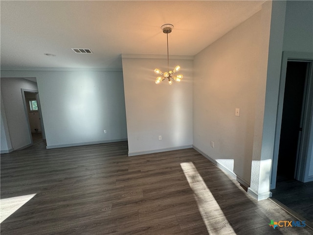 empty room with an inviting chandelier and dark hardwood / wood-style flooring