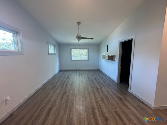 unfurnished living room featuring dark hardwood / wood-style flooring, vaulted ceiling, and ceiling fan