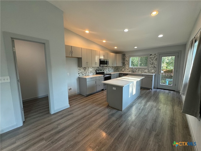 kitchen featuring gray cabinets, appliances with stainless steel finishes, a kitchen island, and dark hardwood / wood-style flooring