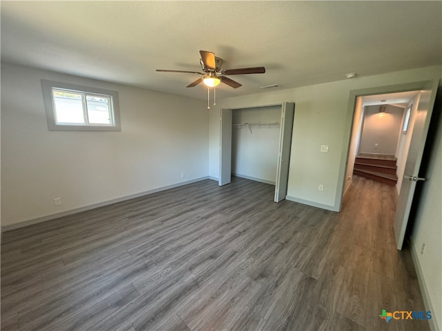 unfurnished bedroom featuring ceiling fan, dark hardwood / wood-style floors, and a closet