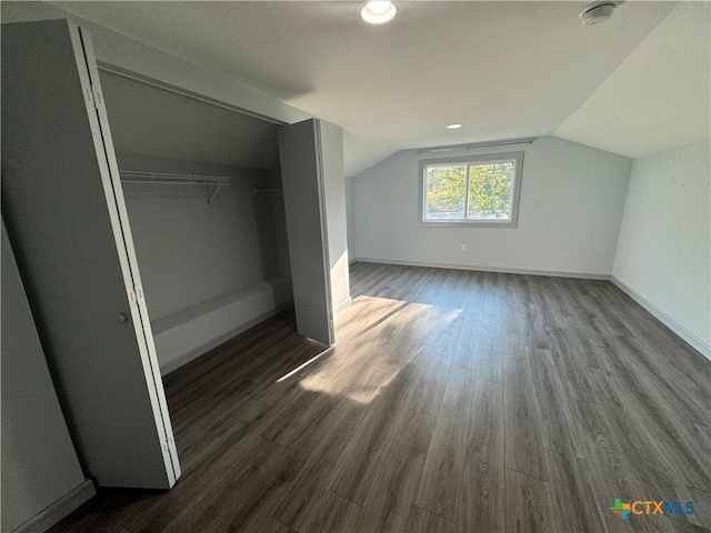 bonus room with dark wood-type flooring and lofted ceiling