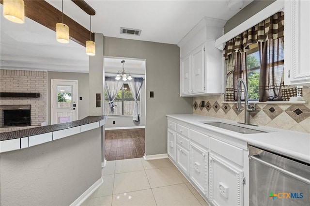 1008 Woodshadows Dr, Harker Heights, TX 76548 - kitchen with dishwasher, tasteful backsplash, white cabinets, pendant lighting, and a chandelier