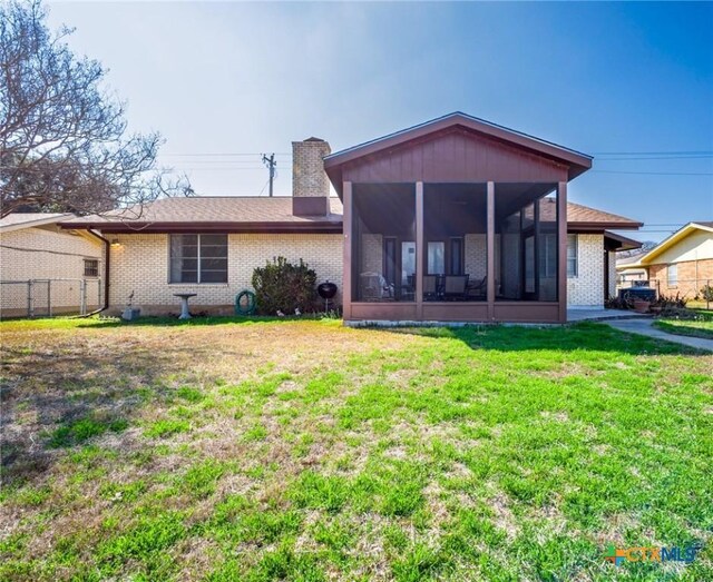 106 Flamingo Cir, Marble Falls, TX 78654 - rear view of property with a sunroom, a chimney, and brick siding