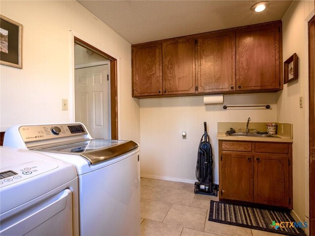 106 Flamingo Cir, Marble Falls, TX 78654 - clothes washing area with cabinet space, washing machine and dryer, light tile patterned flooring, and baseboards
