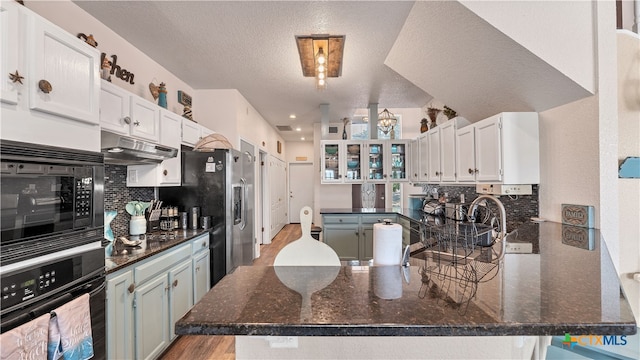 kitchen with appliances with stainless steel finishes, white cabinets, and kitchen peninsula