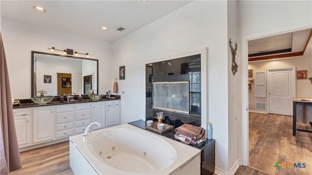 bathroom featuring vanity, hardwood / wood-style flooring, and a tub