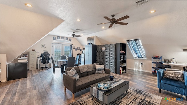 living room with hardwood / wood-style flooring, vaulted ceiling, and a textured ceiling