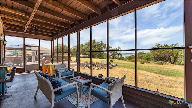 sunroom featuring wood ceiling, beam ceiling, and plenty of natural light