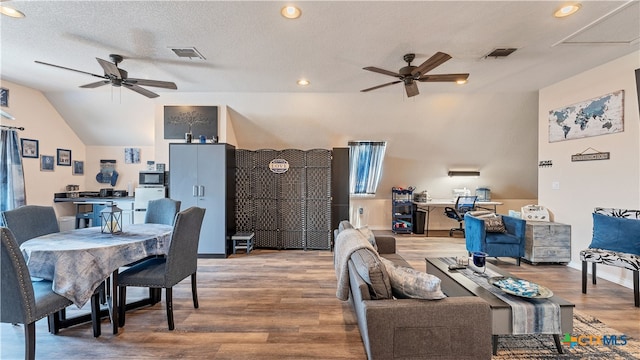 living room featuring ceiling fan, lofted ceiling, hardwood / wood-style floors, and a textured ceiling