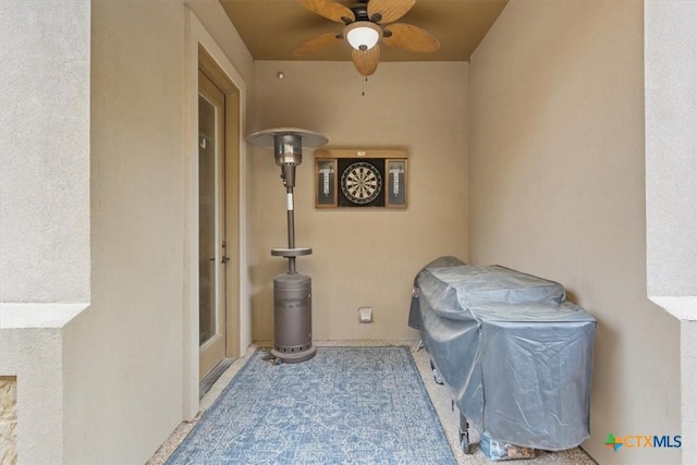 exterior space with a ceiling fan and stucco siding