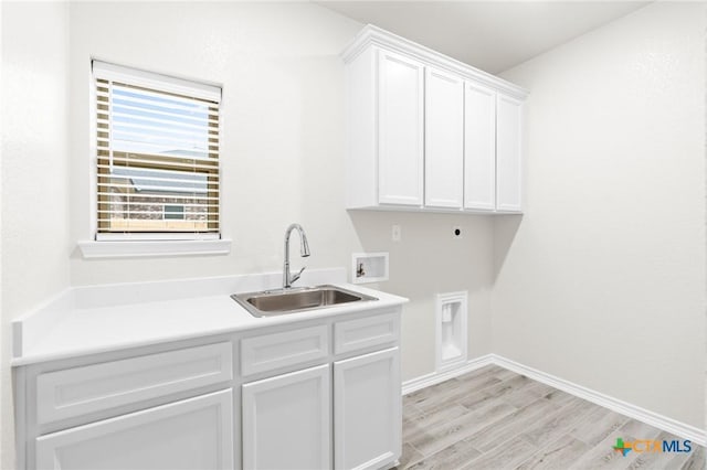 laundry area featuring sink, cabinets, washer hookup, hookup for an electric dryer, and light hardwood / wood-style floors