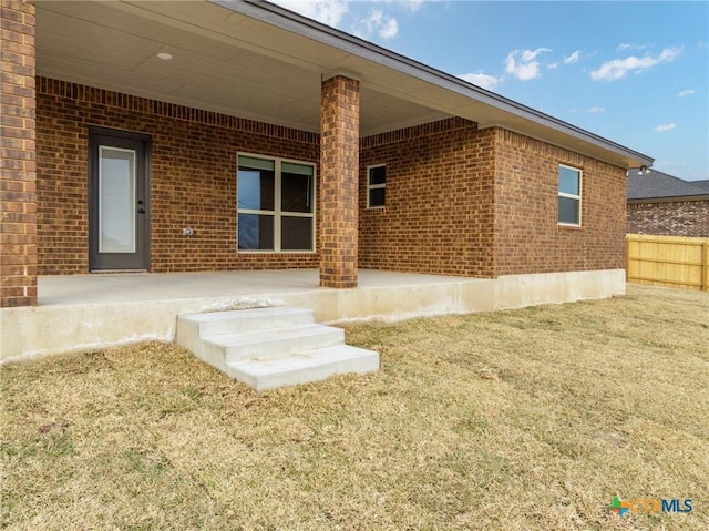 rear view of property featuring a patio and a lawn