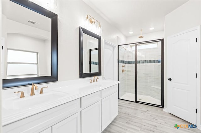 bathroom featuring hardwood / wood-style flooring, vanity, and a shower with shower door