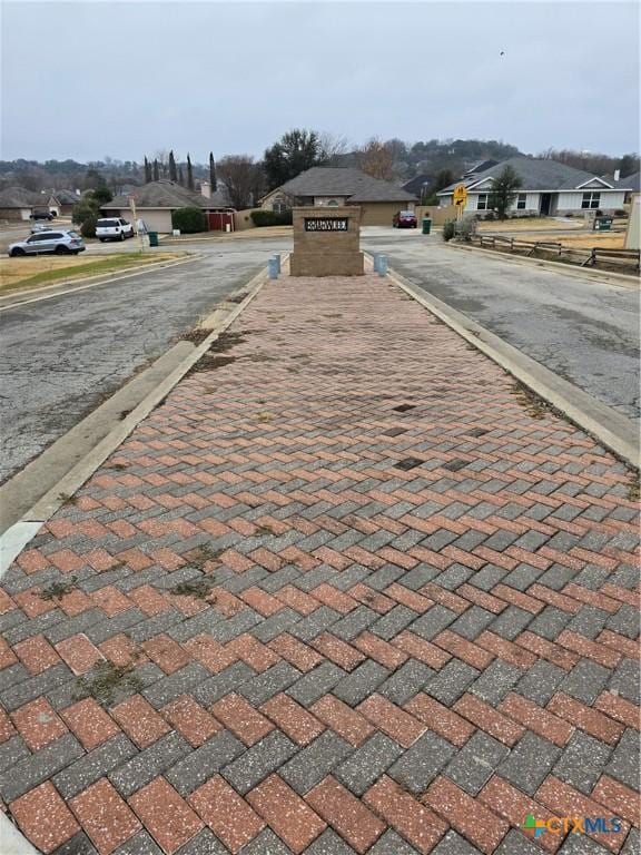 view of road with a residential view and curbs