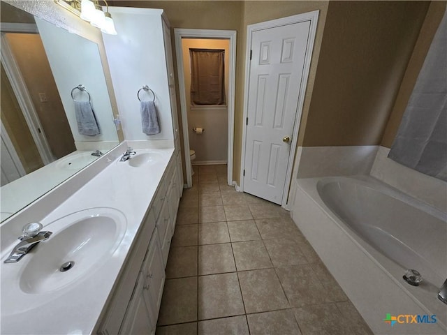 bathroom featuring tile patterned floors, toilet, a bathtub, and vanity