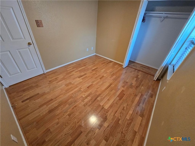 unfurnished bedroom with a closet and light hardwood / wood-style flooring