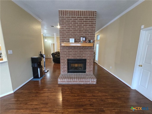 living room featuring crown molding, dark hardwood / wood-style flooring, and a brick fireplace