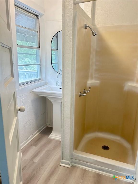 1108 S 47th St, Temple, TX 76504 - full bath featuring wood finished floors, a shower, and a textured wall
