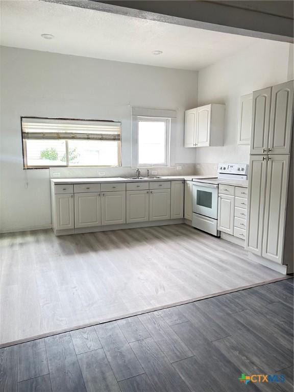 1108 S 47th St, Temple, TX 76504 - kitchen featuring white electric range oven, light countertops, and light wood-type flooring