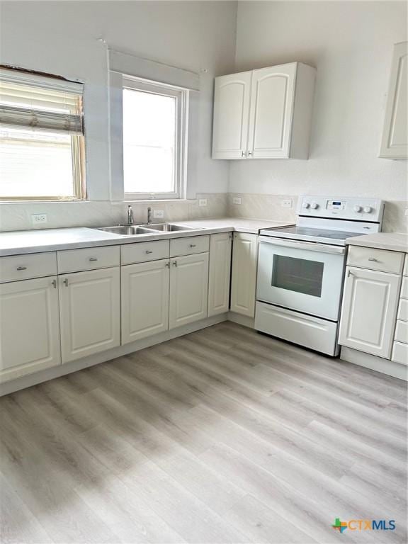 1108 S 47th St, Temple, TX 76504 - kitchen featuring white electric range oven, light countertops, white cabinetry, and light wood-type flooring