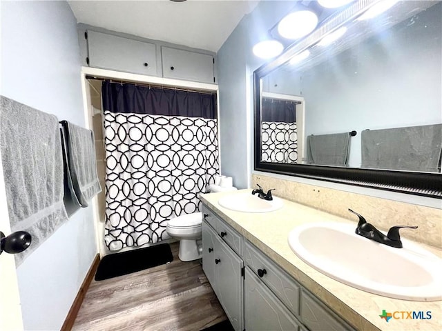 bathroom featuring wood-type flooring, vanity, and toilet