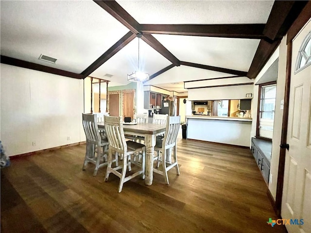 dining area with vaulted ceiling with beams and dark hardwood / wood-style floors