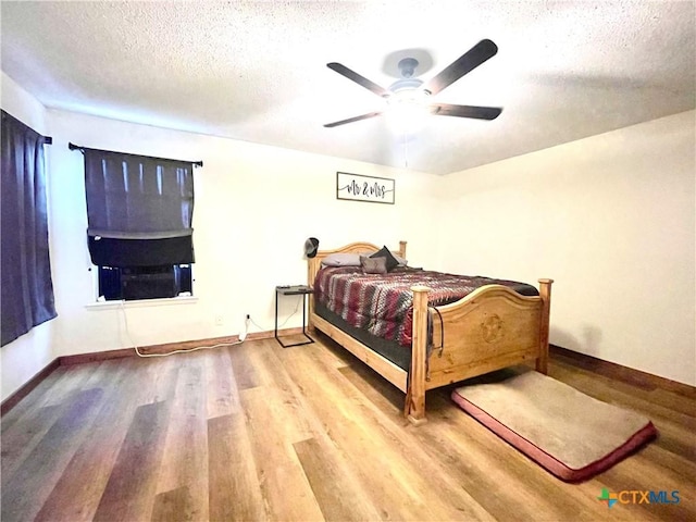 bedroom featuring ceiling fan, a textured ceiling, and light wood-type flooring