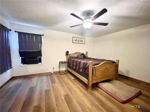 bedroom featuring hardwood / wood-style flooring, a textured ceiling, and ceiling fan