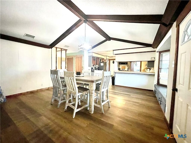 dining room featuring an inviting chandelier, dark wood-type flooring, and lofted ceiling with beams