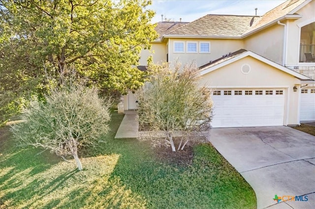 view of front of property featuring a front yard and a garage