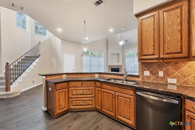 kitchen with sink, decorative light fixtures, dishwasher, kitchen peninsula, and dark hardwood / wood-style floors