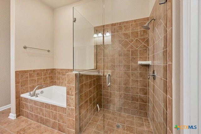 bathroom featuring tile patterned flooring and shower with separate bathtub