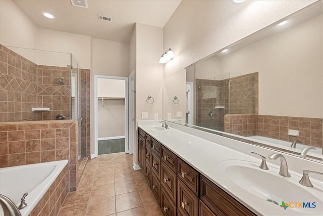 bathroom featuring tile patterned flooring, separate shower and tub, and vanity