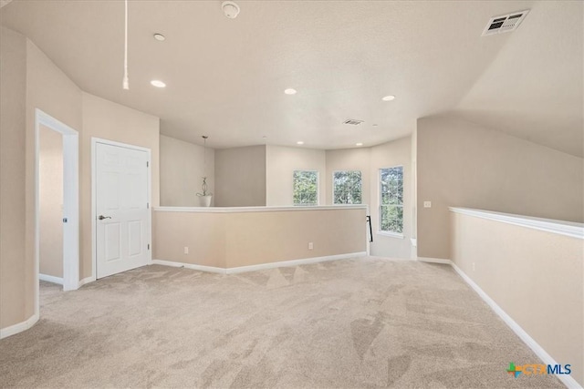 carpeted spare room featuring lofted ceiling