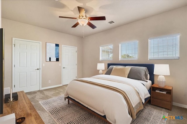 bedroom featuring light colored carpet and ceiling fan