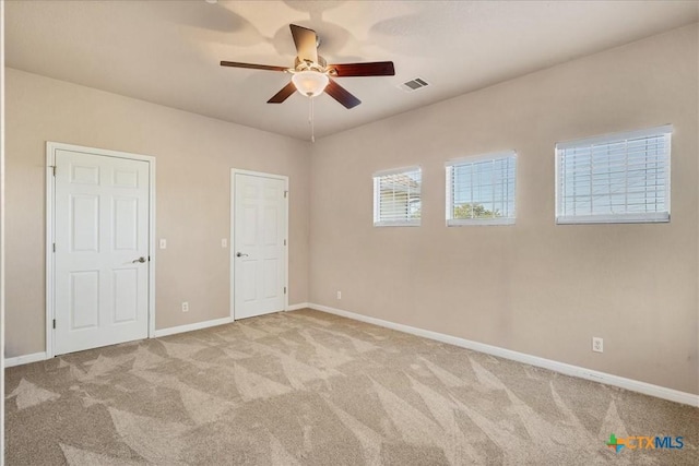 unfurnished bedroom with light colored carpet and ceiling fan