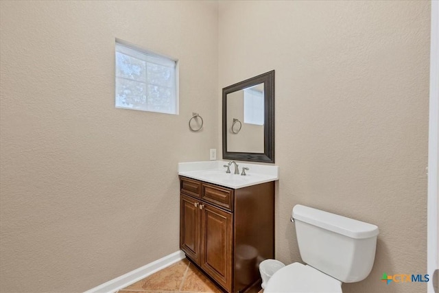 bathroom with toilet, vanity, and tile patterned floors