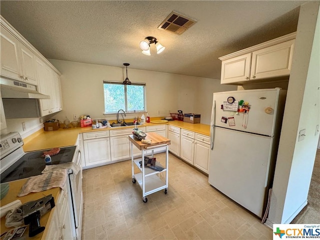 21 Anderson Ln, Coldspring, TX 77331 - kitchen featuring white appliances, under cabinet range hood, a sink, light countertops, and a textured ceiling