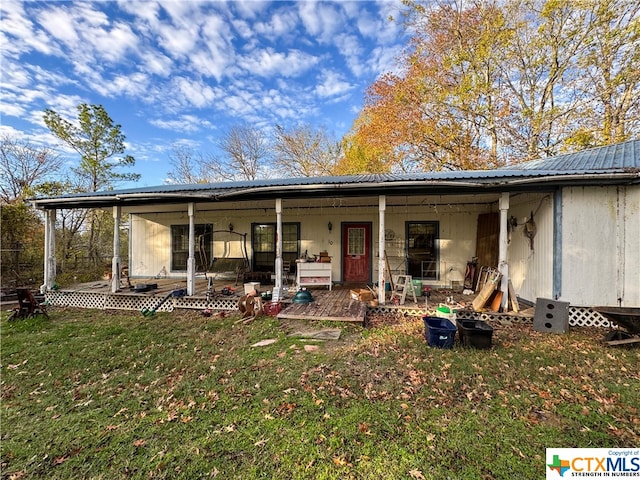 back of property featuring covered porch and a yard